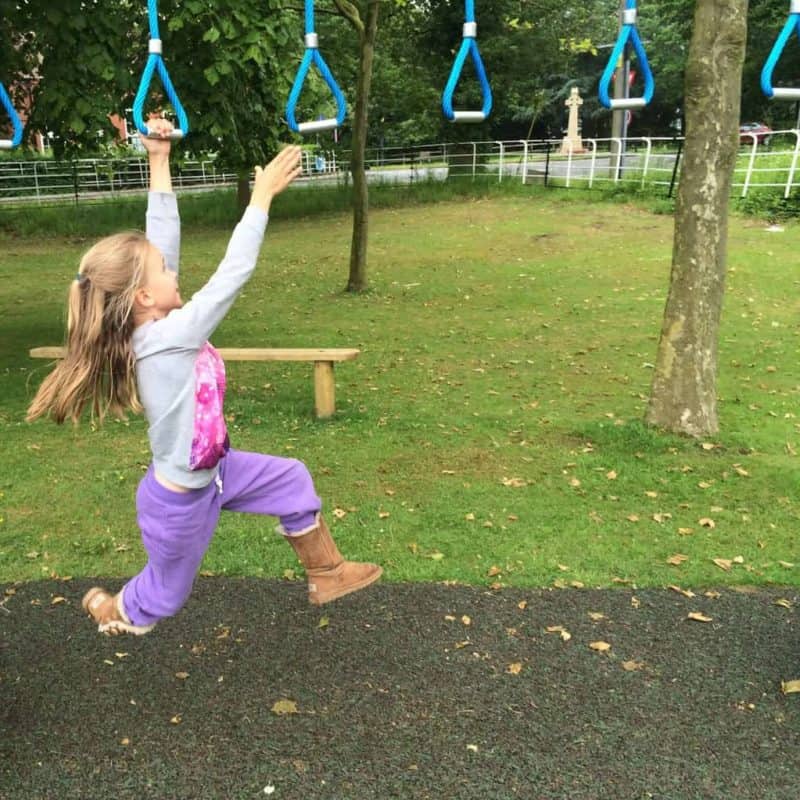 Little girl swinging on monkey bars