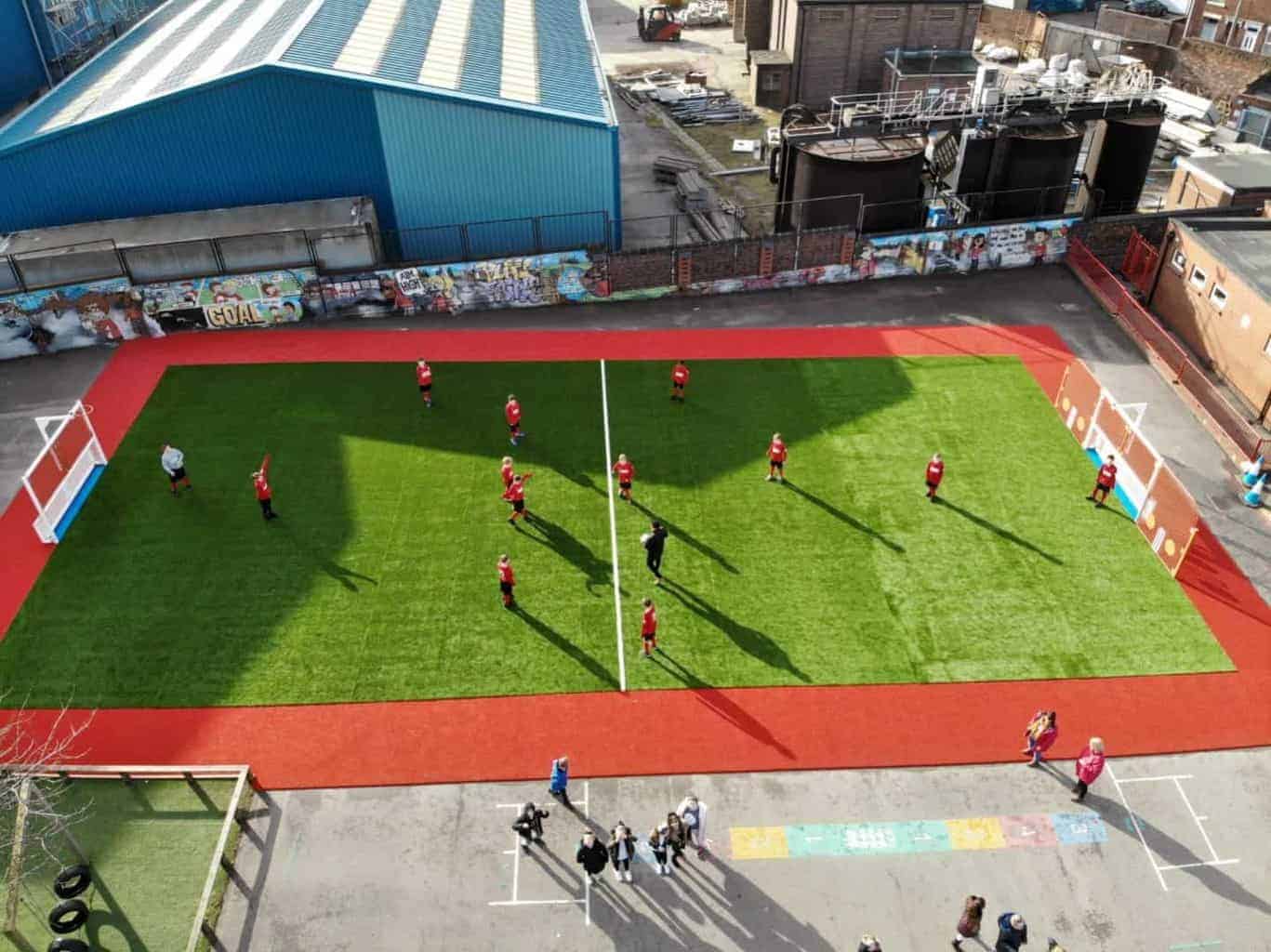 Children playing outdoors on a sports pitch and playground