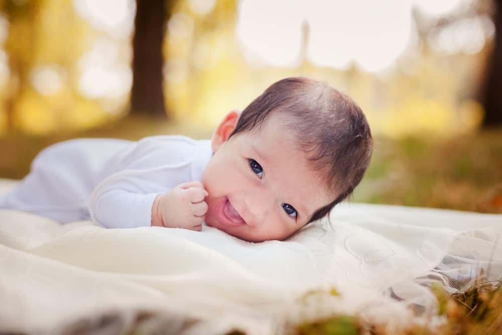 Smiling baby laid on tummy