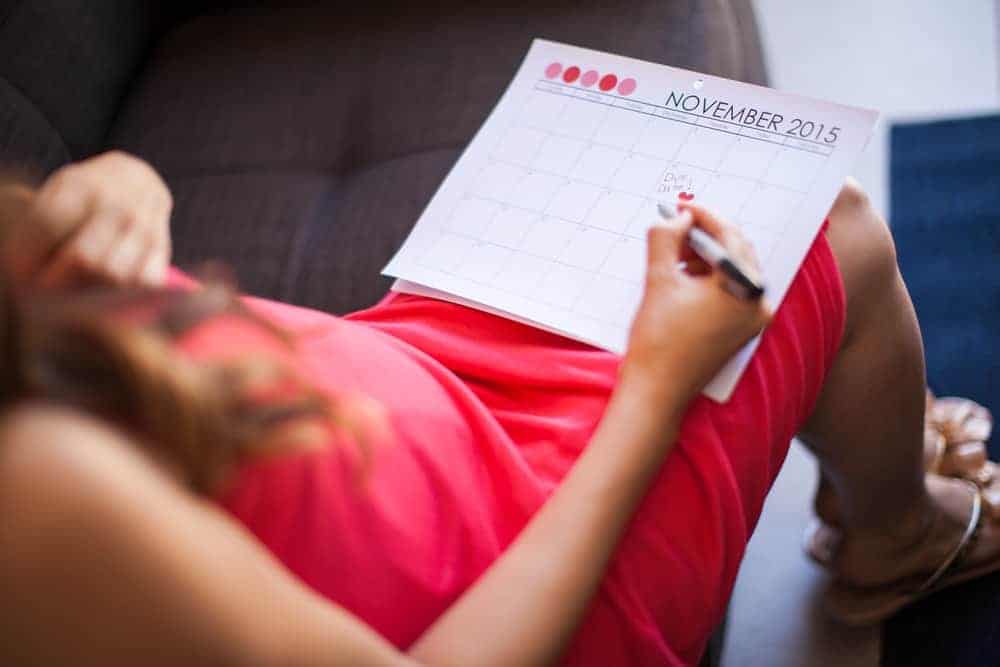 Lady writing her due date on a calendar