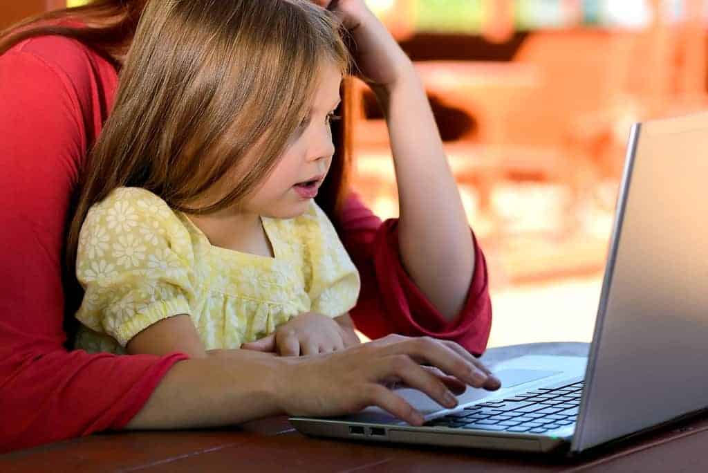 Little girl at computer with parent