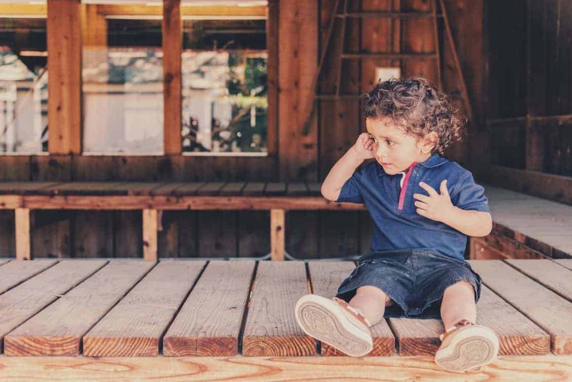 Little boy sitting on front porch