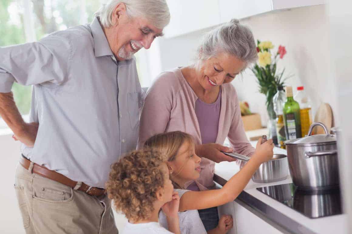 Children happily cooking with grandparents in kitchen