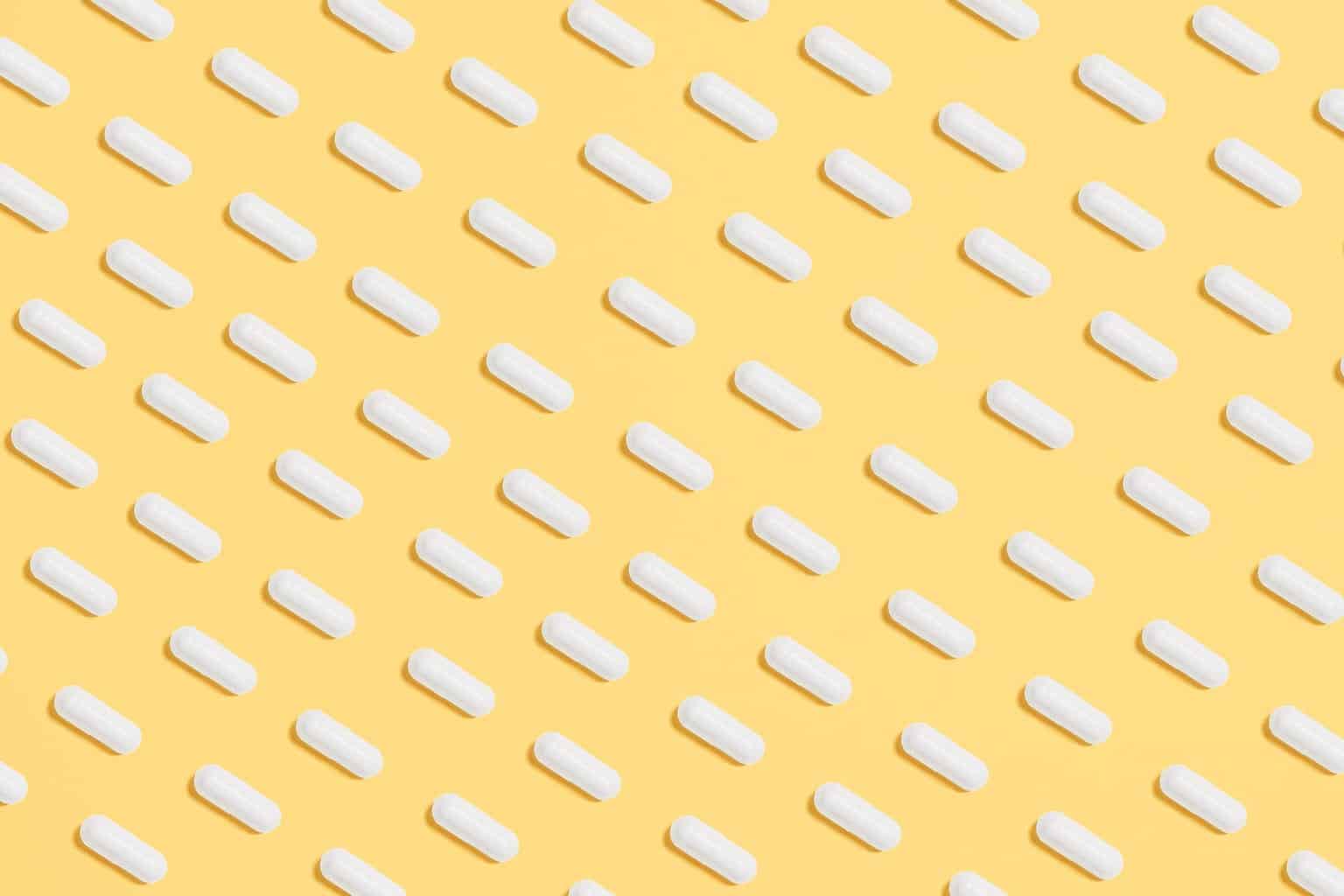 white capsules on yellow background