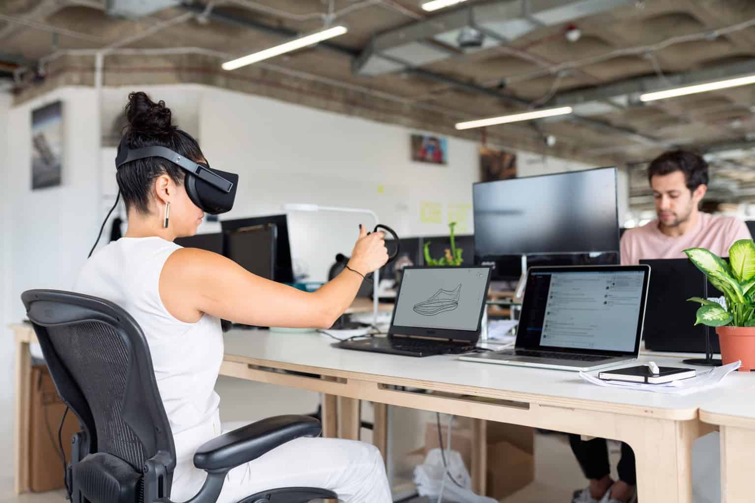 woman in white tank top using black laptop computer with vr headset