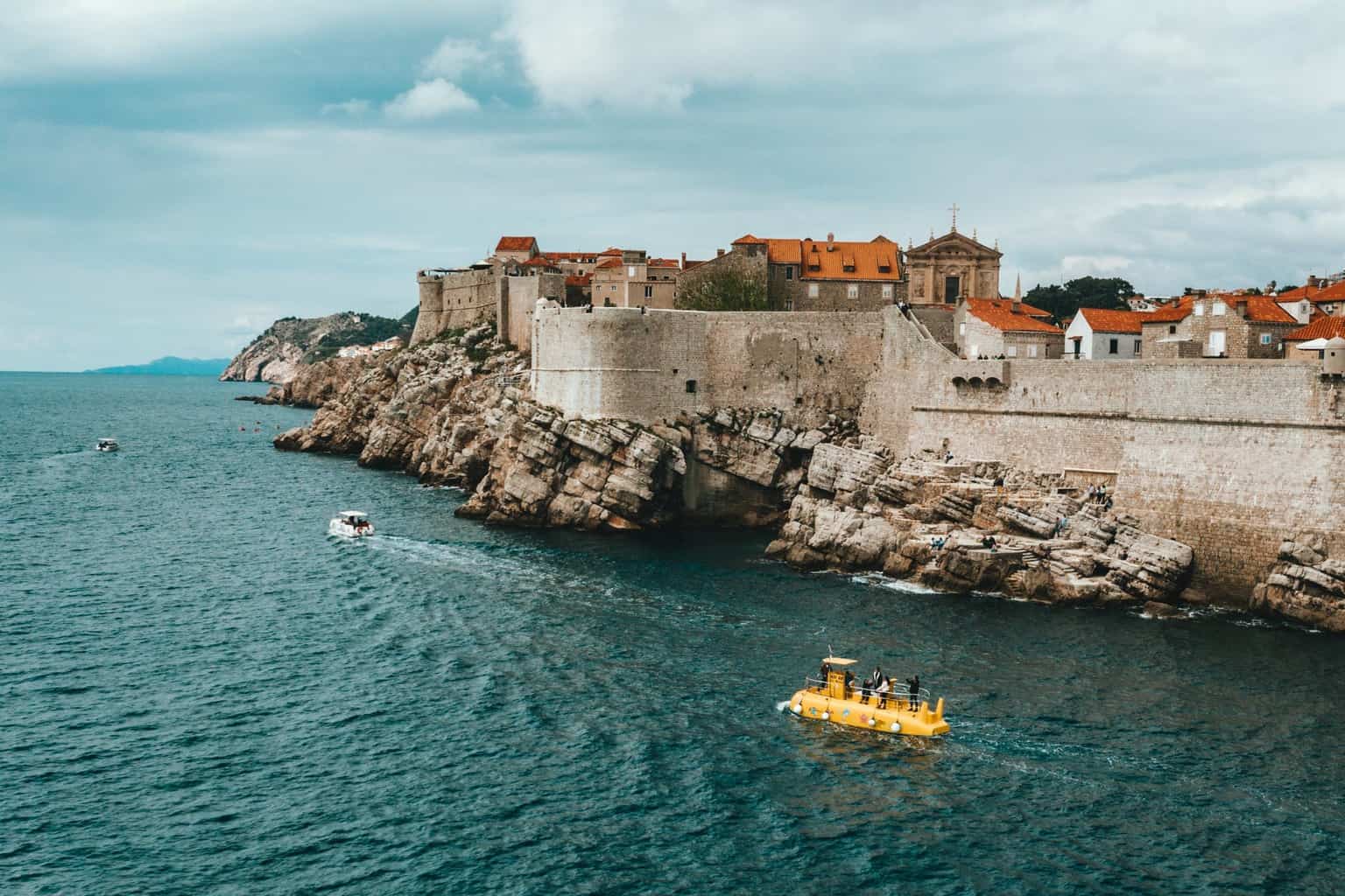 old town on rocky seashore against cloudy sky