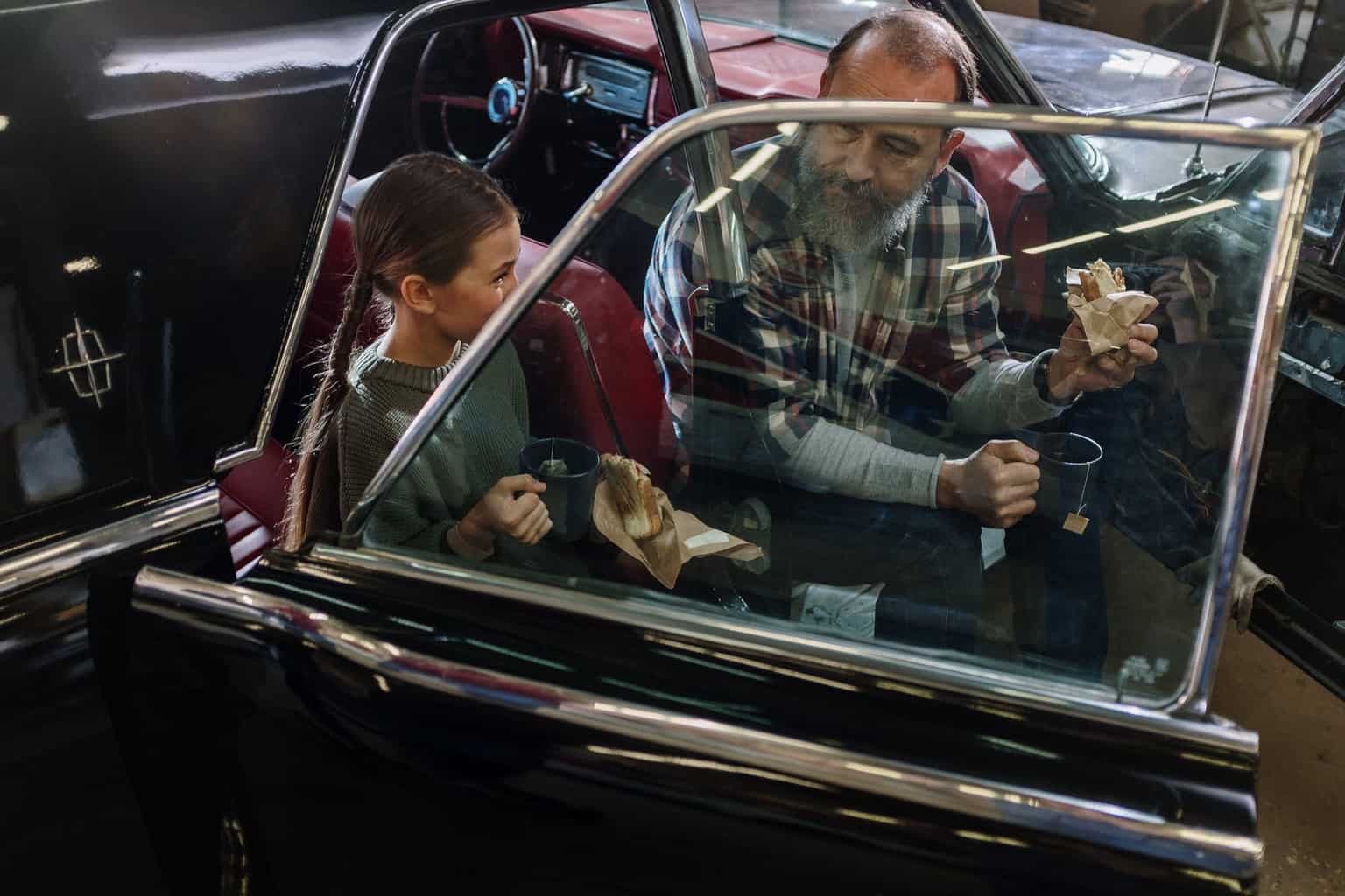 man in blue and white plaid dress shirt driving car