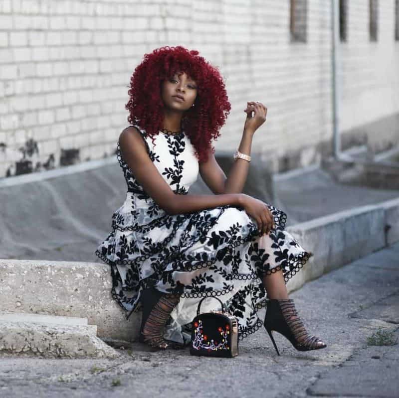 red haired woman in white and black floral sleeveless maxi dress