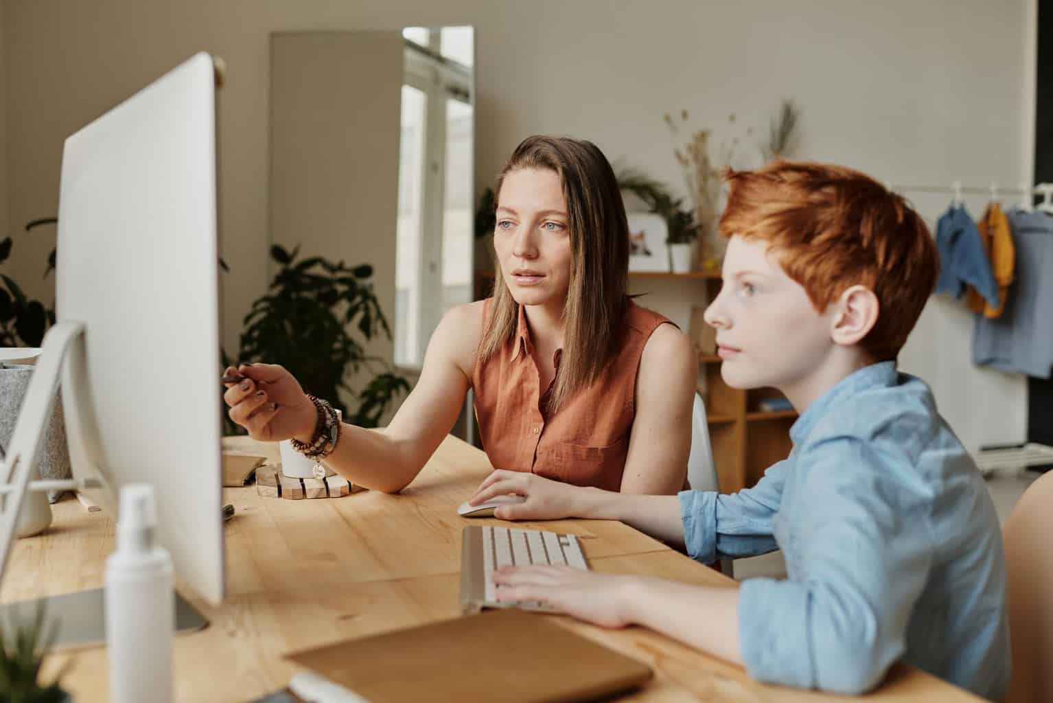 photo of woman teaching his son