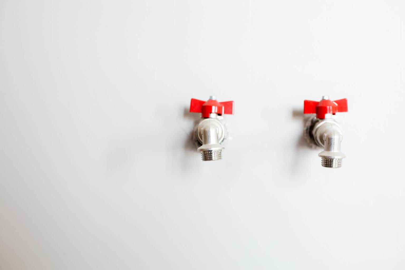 photo of faucets on white wall