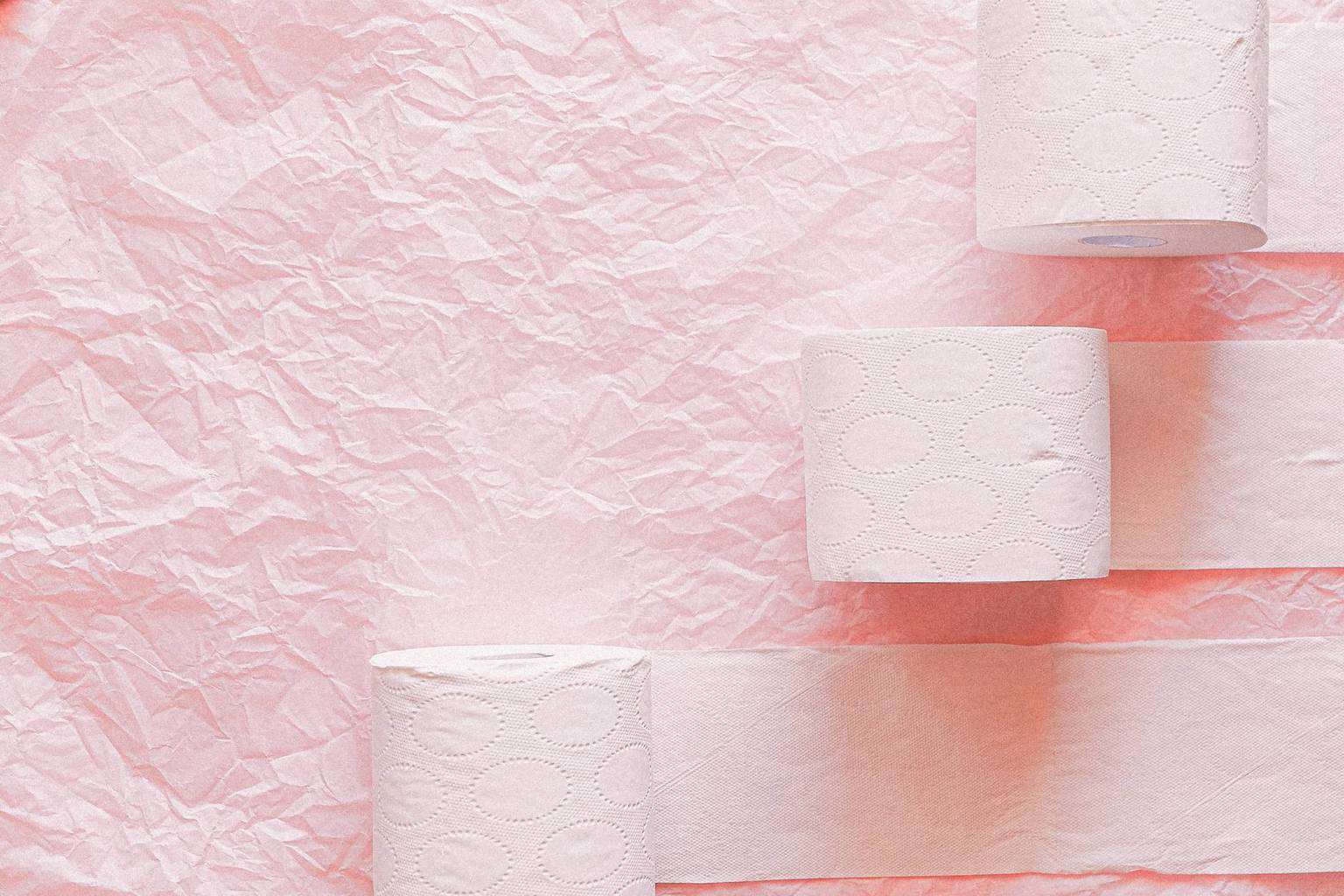 white toilet paper roll on pink textile
