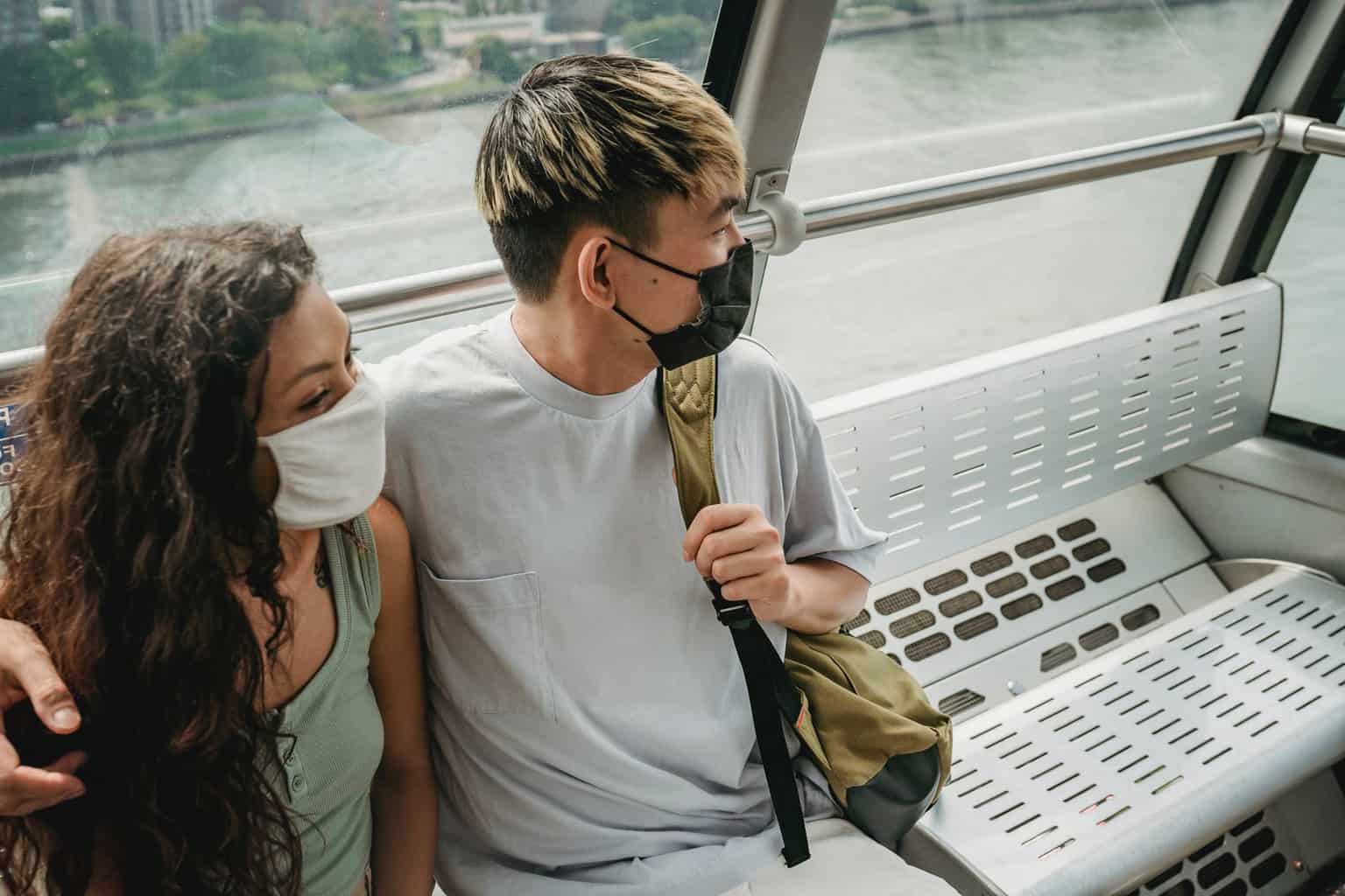 couple hugging and riding cableway cabin above modern city river