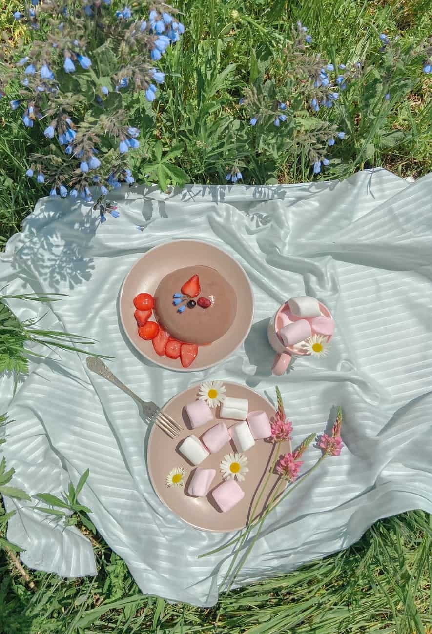 delicious sweet marshmallows near plate with cake decorated with berries