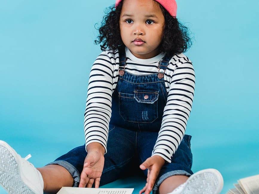 puzzled black girl sitting with books