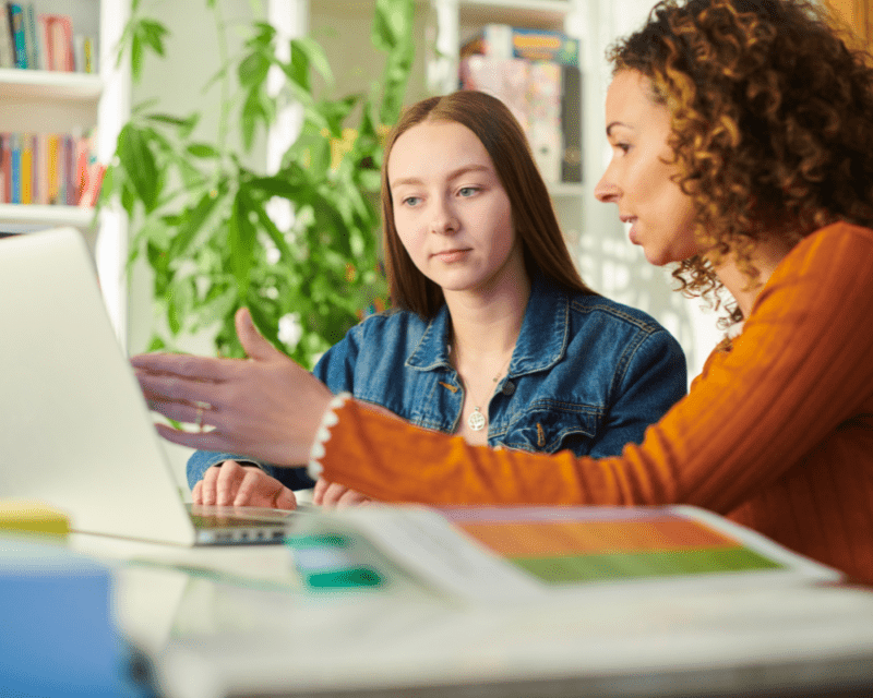 a woman and a woman looking at a laptop