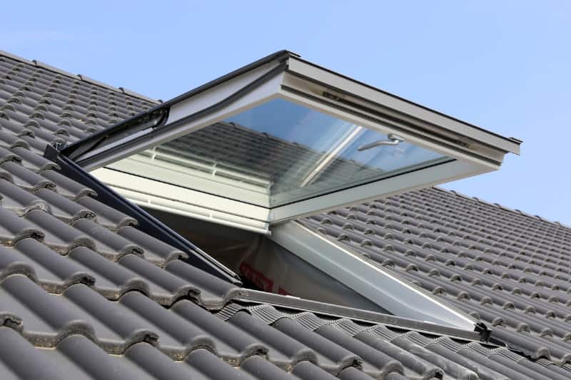 Operable skylight open on a tiled roof.