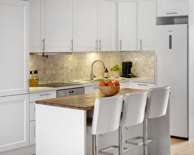 a kitchen with white cabinets and white countertops