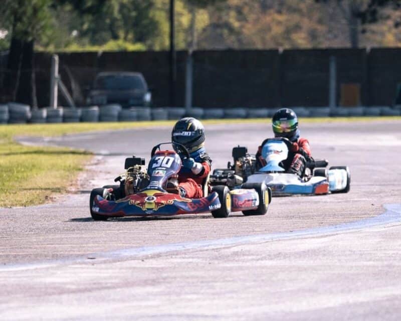 a couple of people driving go karts on a track