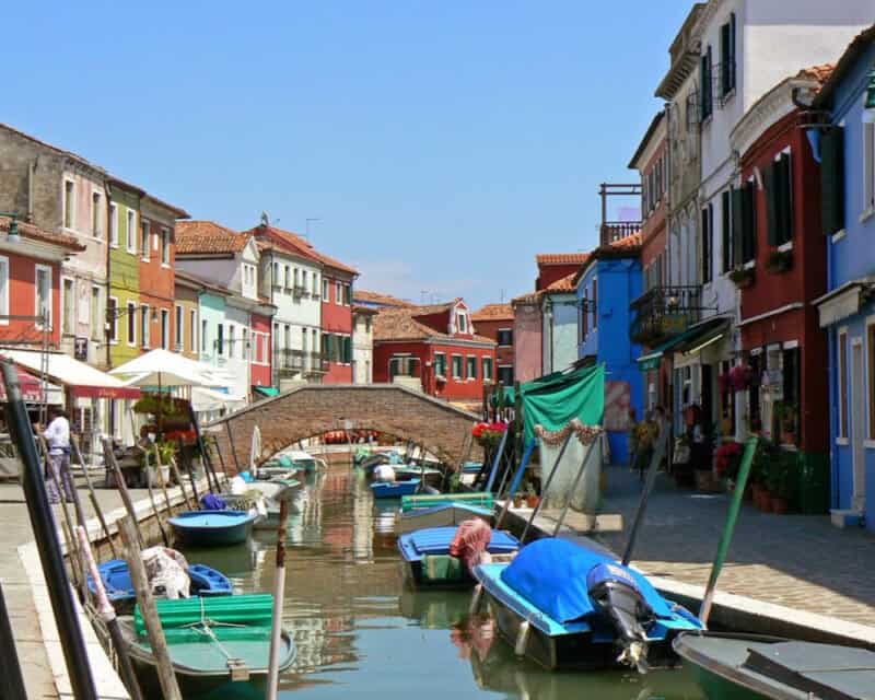 boats in a canal with boats and buildings in Murano