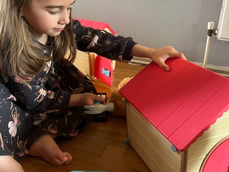 a girl playing with a toy house