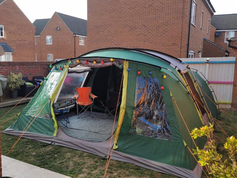 a tent with lights and chairs in front of a brick building