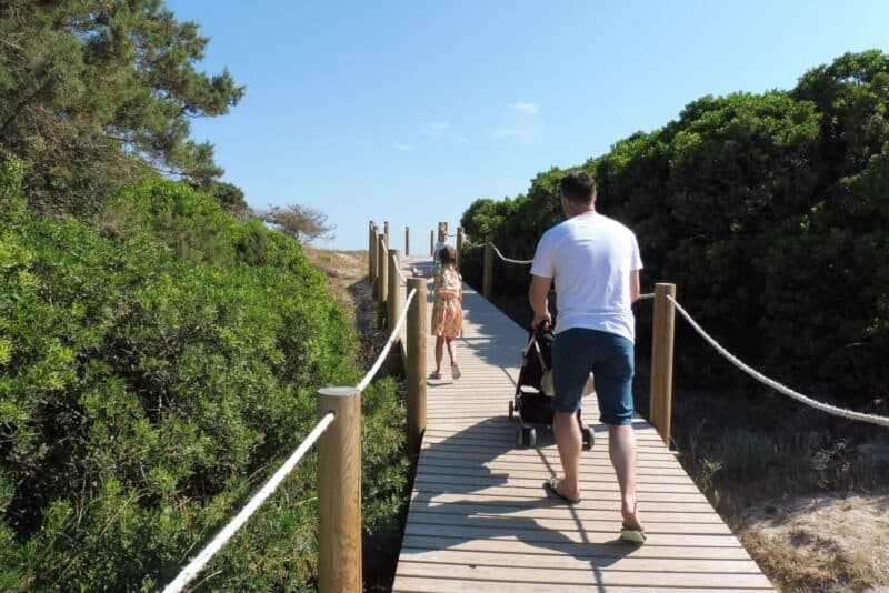 a man and woman walking on a wooden walkway