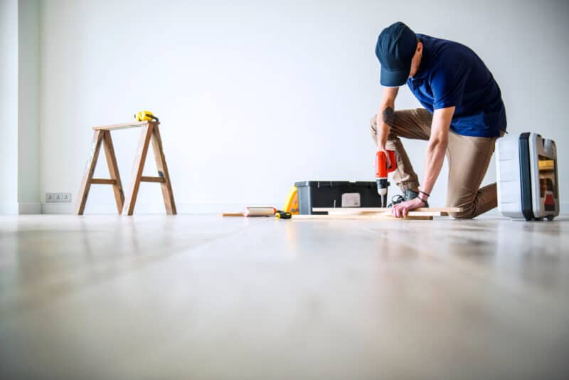 a man using a drill to drill a piece of wood