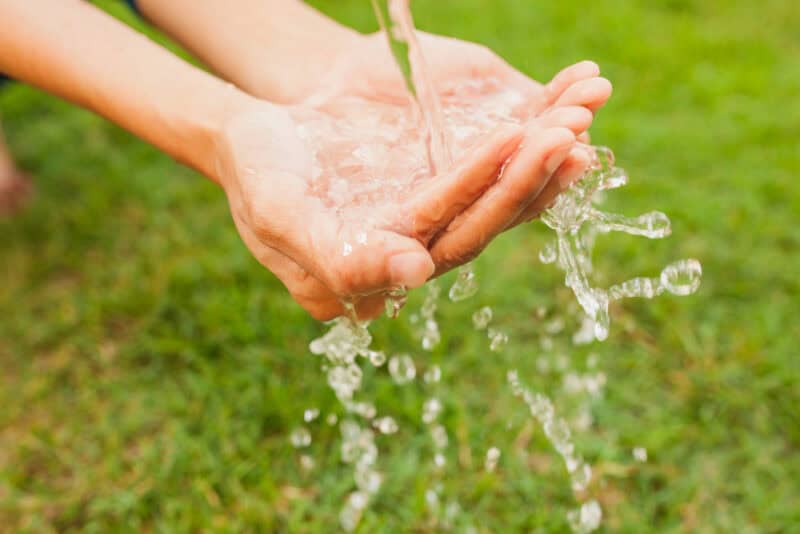 a person's hands pouring water into their hands