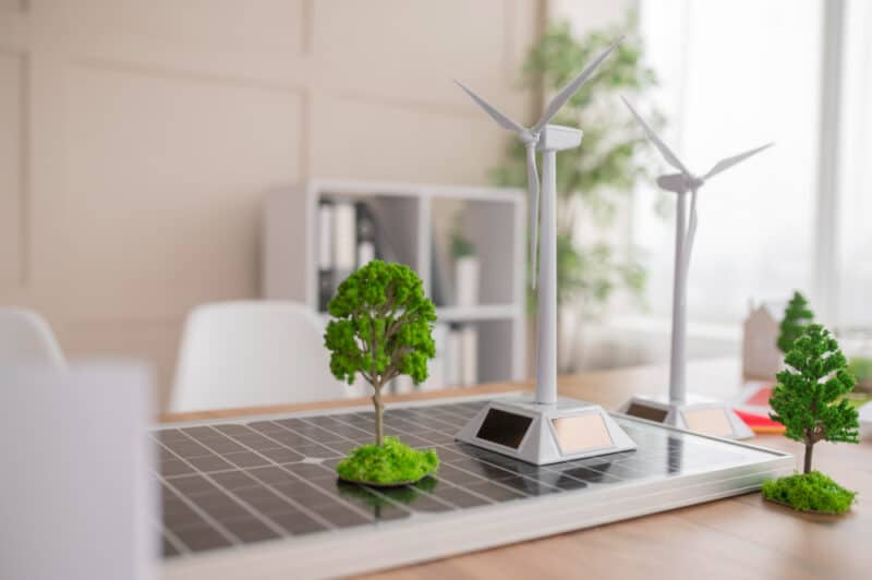 a solar panel with a tree and wind turbines on it