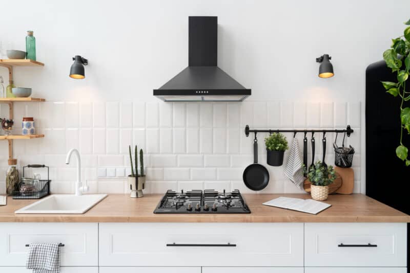 a kitchen with white cabinets and black appliances