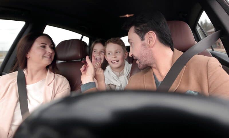 a man and two children in a car