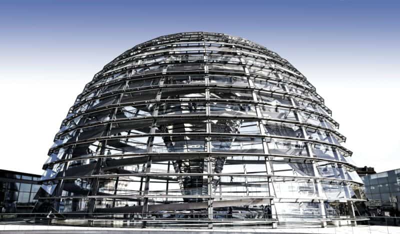 a glass dome with a spiral staircase with Reichstag dome in the background