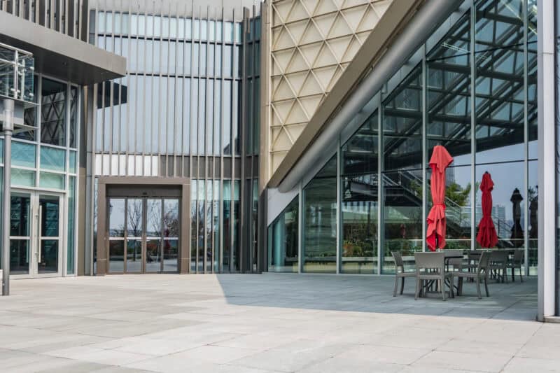 a metal building with glass walls and a patio