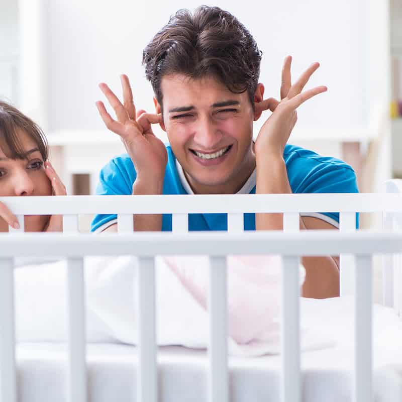 a man and woman in a crib